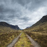 Route montagneuse sous un ciel nuageux
