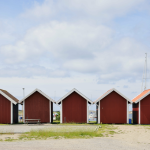 Cabanes de pêche rouges alignées sous un ciel nuageux