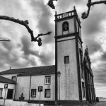 Clocher d'église sous un ciel nuageux en noir et blanc
