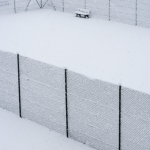 Court de tennis couvert de neige avec un banc en hiver