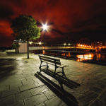 Banc solitaire et pont illuminé au crépuscule
