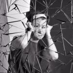 Femme devant un miroir brisé en noir et blanc