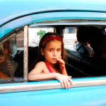 Petite fille regardant par la fenêtre d'une voiture ancienne