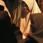 Femmes souriantes en hijab dans un lieu sombre