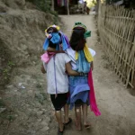 Enfants en costumes traditionnels marchant dans un village