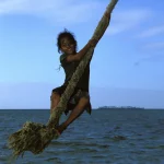 Enfant Jouant Sur Une Corde au Bord de la Mer