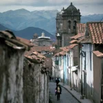 Rue étroite d'une ville coloniale avec montagnes en arrière-plan