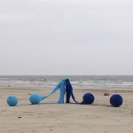 Installation artistique sur la plage avec des ballons bleus