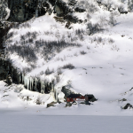 Chalet Rouge Enneigé au Pied d'une Montagne Rocailleuse