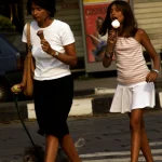 Femme et fille mangeant des glaces en marchant avec un chien