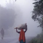 Femme marchant sur une route brumeuse avec un sac sur la tête