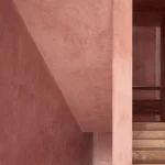 Escalier en béton teinté rouge dans l'angle d'un bâtiment