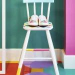 Sneakers blanches à motifs colorés sur une chaise