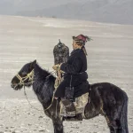 Cavalier mongol avec son aigle sur la steppe enneigée