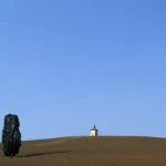 Petit bâtiment isolé sur une colline sous un ciel bleu