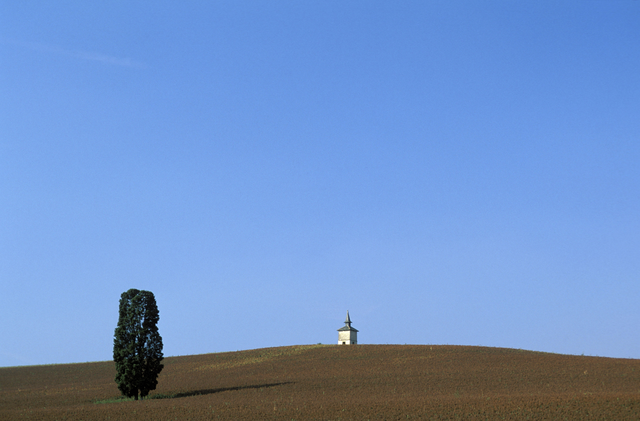 AKG887436.webp Petit bâtiment isolé sur une colline sous un ciel bleu – Image 1