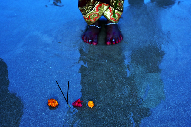 AKG8880343.webp Fleurs et encens sur le sable avec pieds en arrière-plan – Image 1