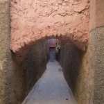 Ruelle étroite avec arche de pierre rose