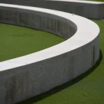 Cloison cintrée en béton sur pelouse verte