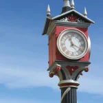 Horloge traditionnelle rouge sur ciel bleu étincelant
