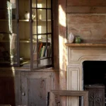 Intérieur rustique avec cheminée et armoire vitrée