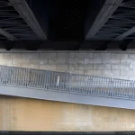 Vue d'en bas d'un pont avec une passerelle et un mur en brique