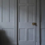 Porte grise avec moulures et plancher en bois