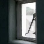 Fenêtre ancienne partiellement ouverte laissant entrer la lumière