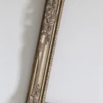 Cadre ancien doré sur mur blanc