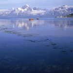Barques sur un lac avec montagnes enneigées