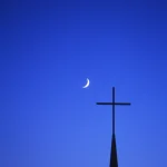 Croissant de lune et croix d'église au crépuscule