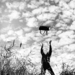 Personne lançant un sac sous un ciel nuageux en extérieur