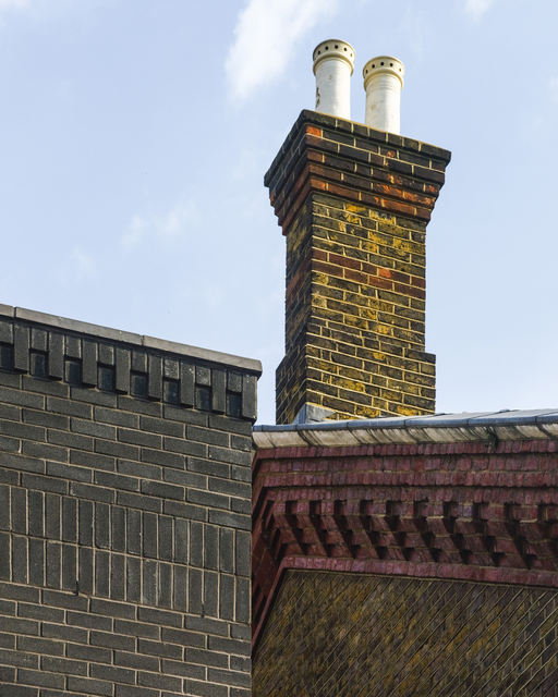 AKG8987674.webp Cheminée en briques avec deux conduits sur un toit – Image 1