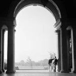 Deux hommes discutant sous un arc monumental