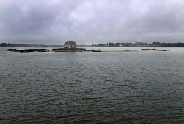 AKG8992933.webp Maison isolée sur une petite île par temps nuageux – Image 1