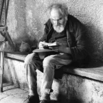 Vieil homme lisant assis sur un banc de pierre