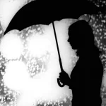 Silhouette d'une femme avec un parapluie sous la pluie