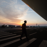Personne marchant à l'extérieur d'un aéroport en soirée