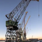 Grues Industrielles le Long d'un Quai au Coucher du Soleil