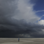 Personne sous un ciel orageux sur une plage