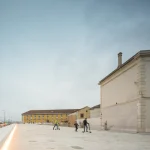 Trois personnes en trottinette devant bâtiments historiques