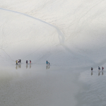 Groupe de personnes marchant sur une plage sablonneuse