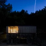 Maison moderne en forêt de nuit