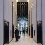 Hall d'entrée d'un immeuble de bureaux avec ascenseurs et hommes d'affaires.