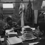Deux hommes travaillant dans un bureau encombré