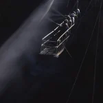 Travailleurs suspendus nettoyant une structure métallique