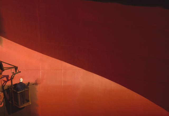 AKG925859.webp Peinture d'une coque de navire par un ouvrier en nacelle. – Image 1