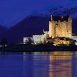 Château illuminé la nuit au bord d'un lac