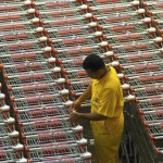 Employé organisant des chariots de supermarché