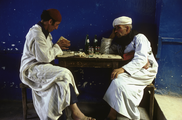 AKG966552.webp Deux hommes partageant un repas dans un café traditionnel – Image 1